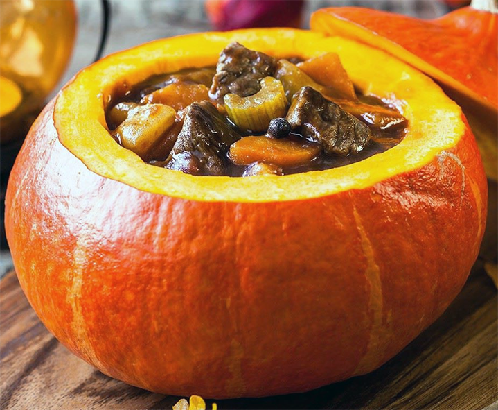 beef and vegetable stew served in a hollowed out pumpkin