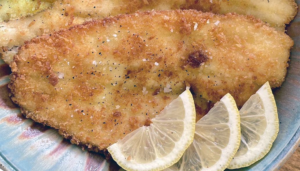 fried breaded flounder garnished with lemon slices