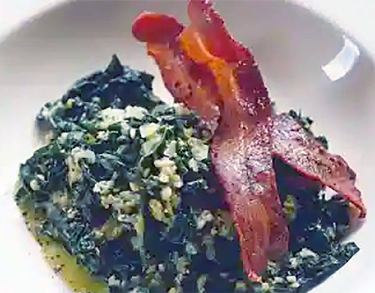 oatmeal porridge mixed with cavalo nero served topped with two rashers of streaky bacon