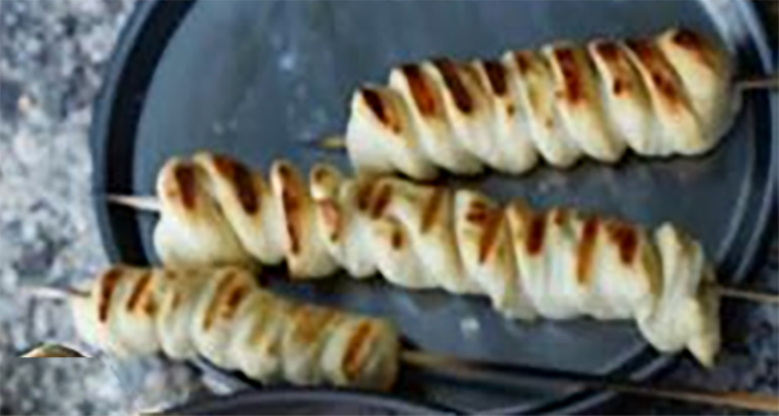 campfire stick biscuits on a metal plate
