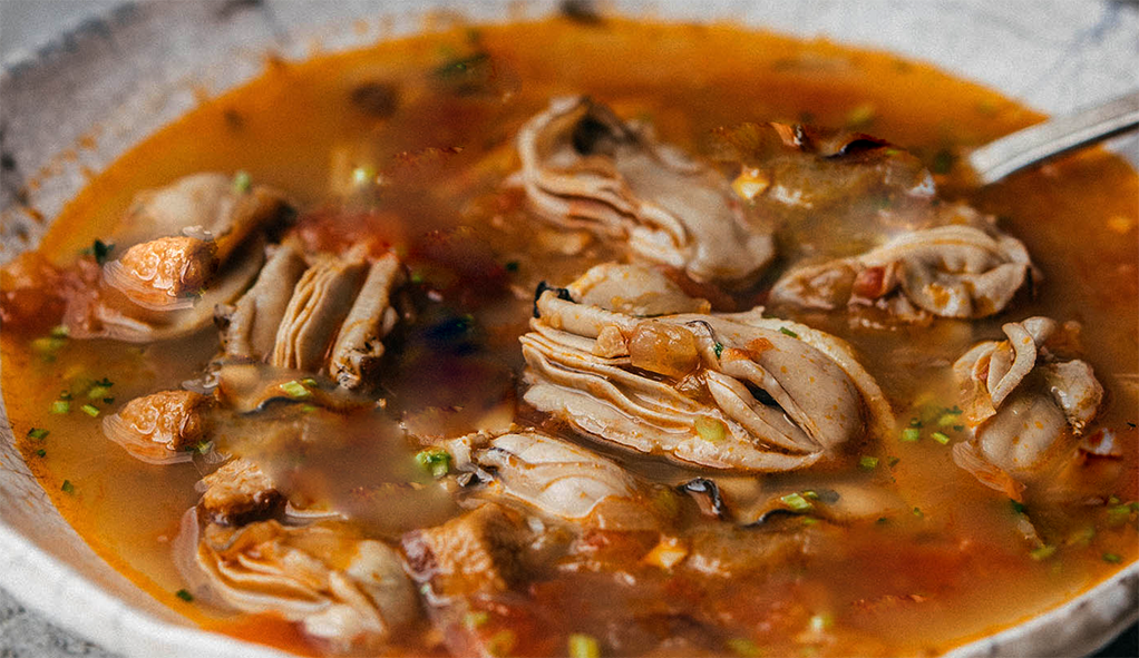 brown oyster soup in a shallow soup bowl