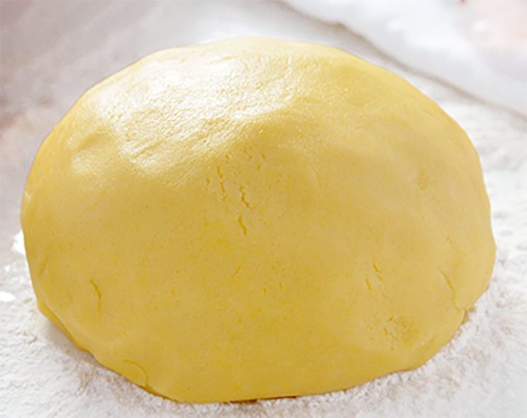 ball of pasta frolla, italian sweet shortcrust pastry on a floured work surface</a>
