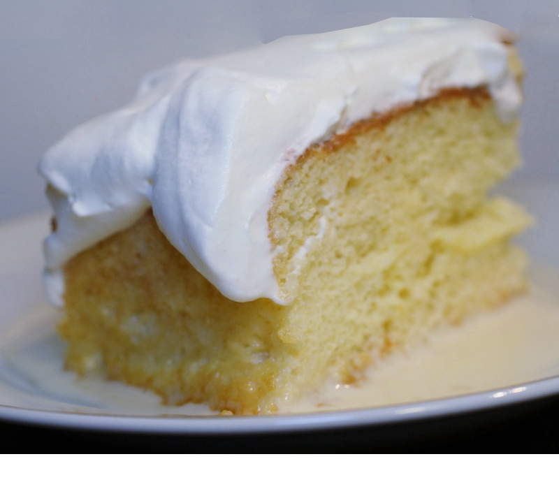 slice of iced pastel de tres leches on a plate