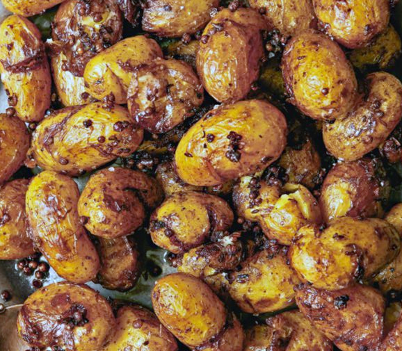 Patates Antinaktes, fried crushed new potatoes in red wine with coriander seeds served on a plate