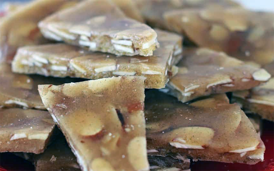 pieces of toffee containing slivered almonds on a plate