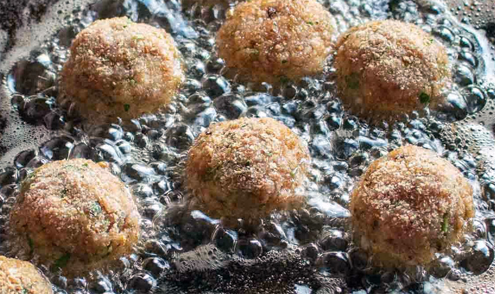 breaded beef meatballs frying in oil