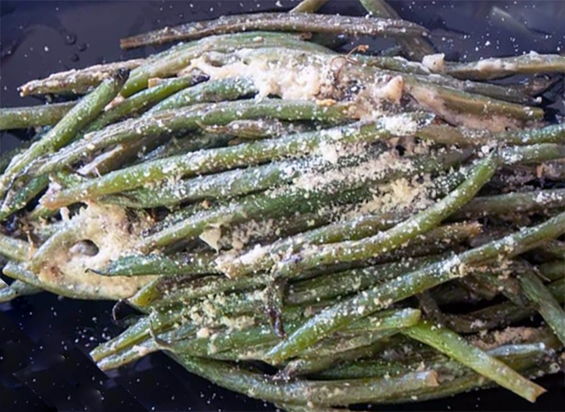 fricasseed french beans on a black plate