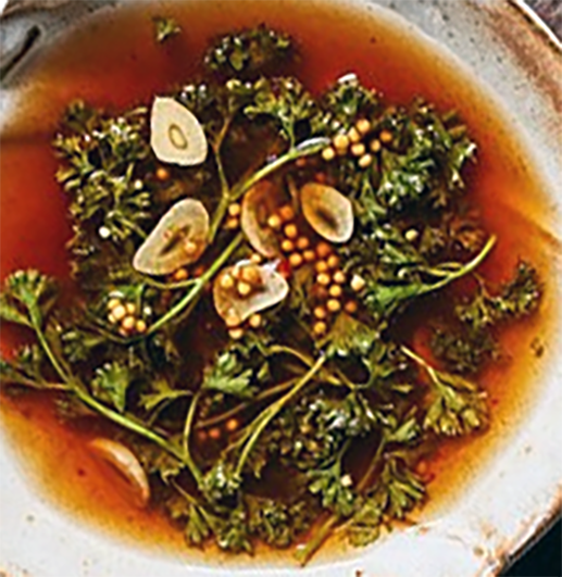 pickled parsley piert with garlic and mustard seeds on a  plate