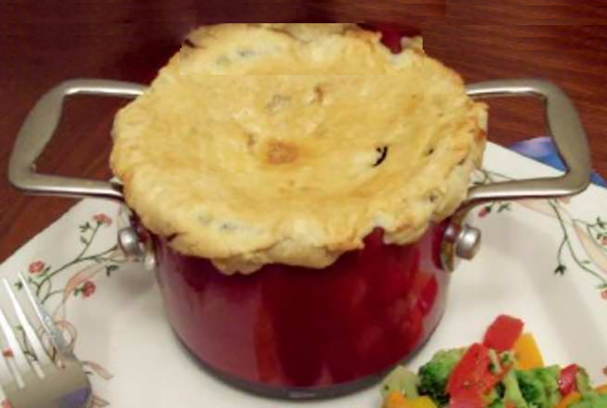 pastry-topped pork ciste in a tall metal dish
