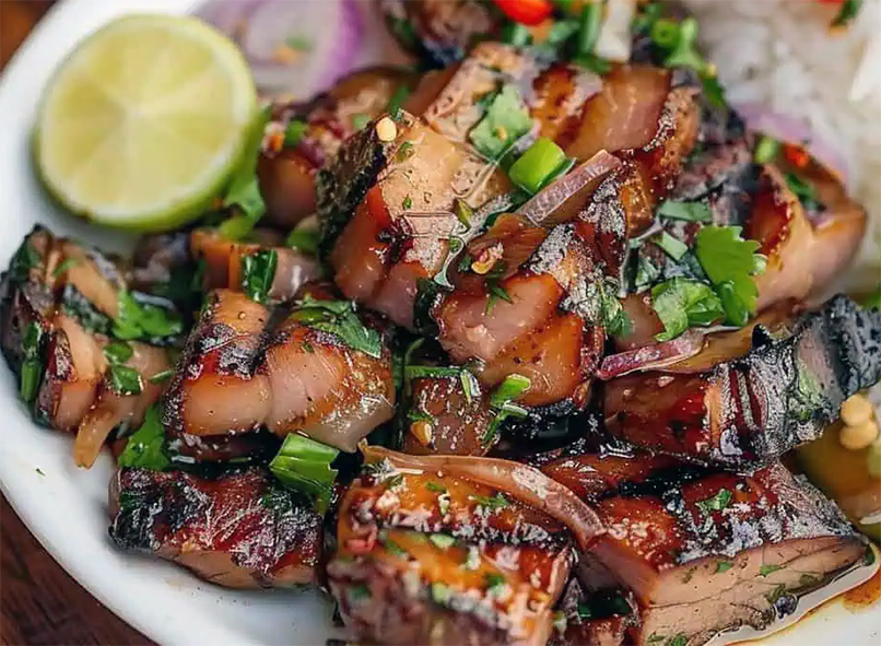 pork kilawin on a plate with lime and rice