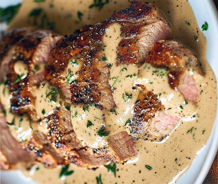 pork tenderloin on a plate with bergamot cream sauce