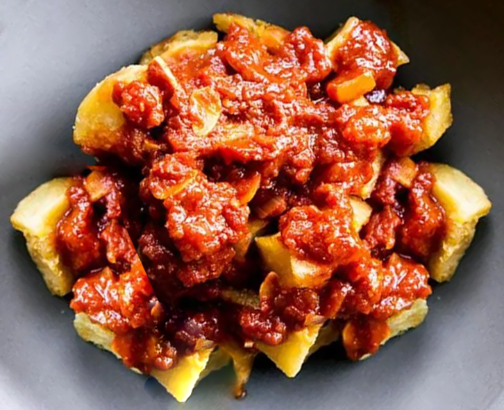 Potato bourekas with spicy tomato sauce in a grey dish