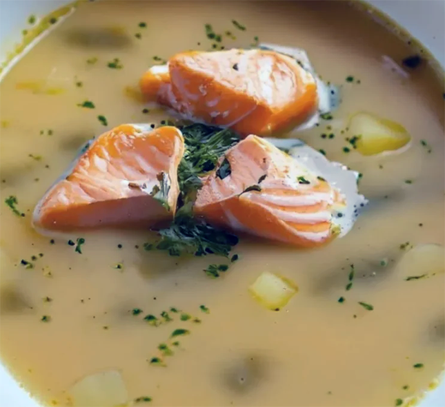 potato soup garnished with chunks of salmon and finely-chopped chives