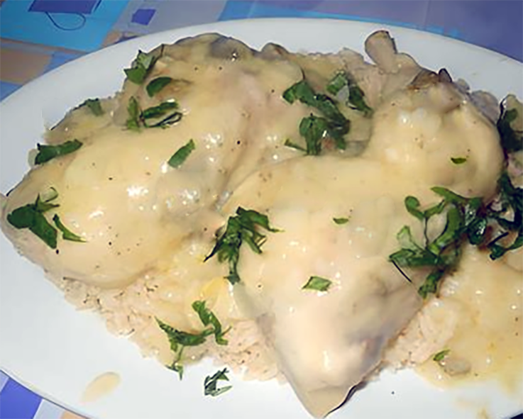 Chicken in white sauce served on a bed of rice