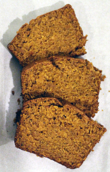 three slices of pumpkin, poppy seed and lemon loaf against a white background
