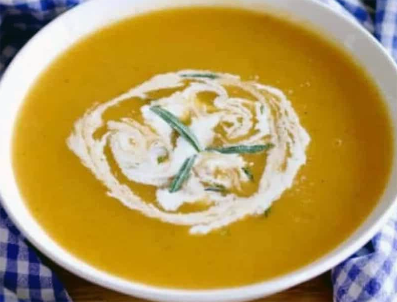 pumpkin and tarragon soup in a bowl garnished with sour cream