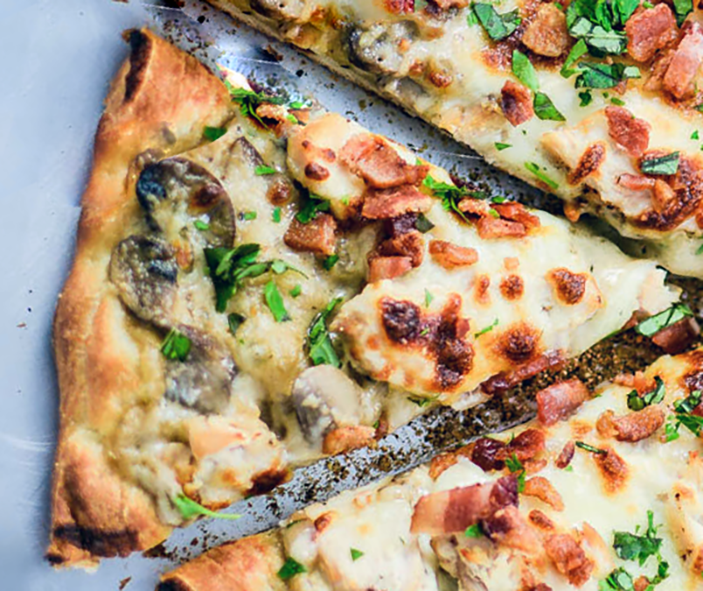 wedge of ranch chicken pizza with mushrooms and bacon