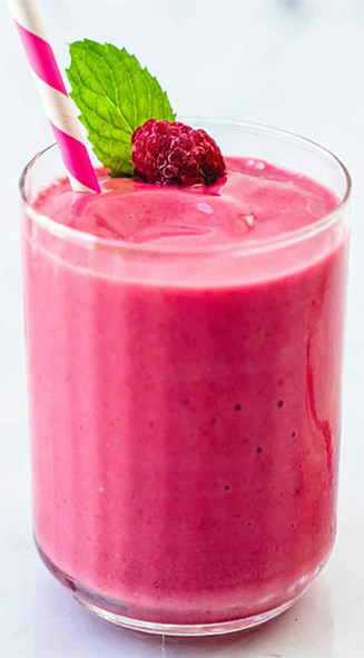 raspberry smoothie garnished with a raspberry and a sprig of mint in a tall glass