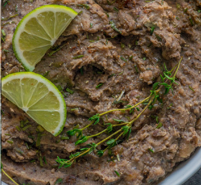 refried carlin peas in a bowl served garnished with lime slices