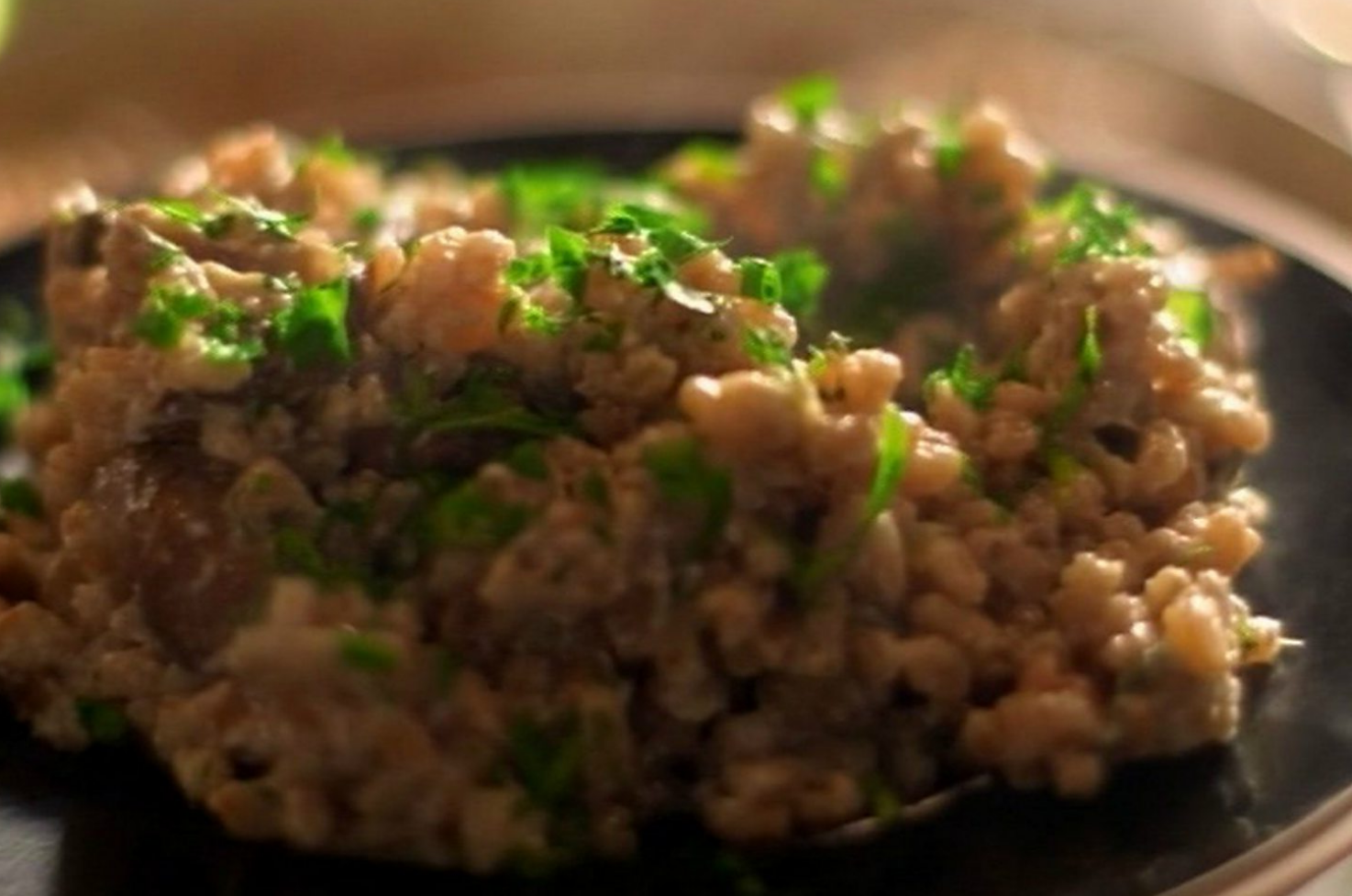 farro risotto with mushrooms and herbs served on a plate