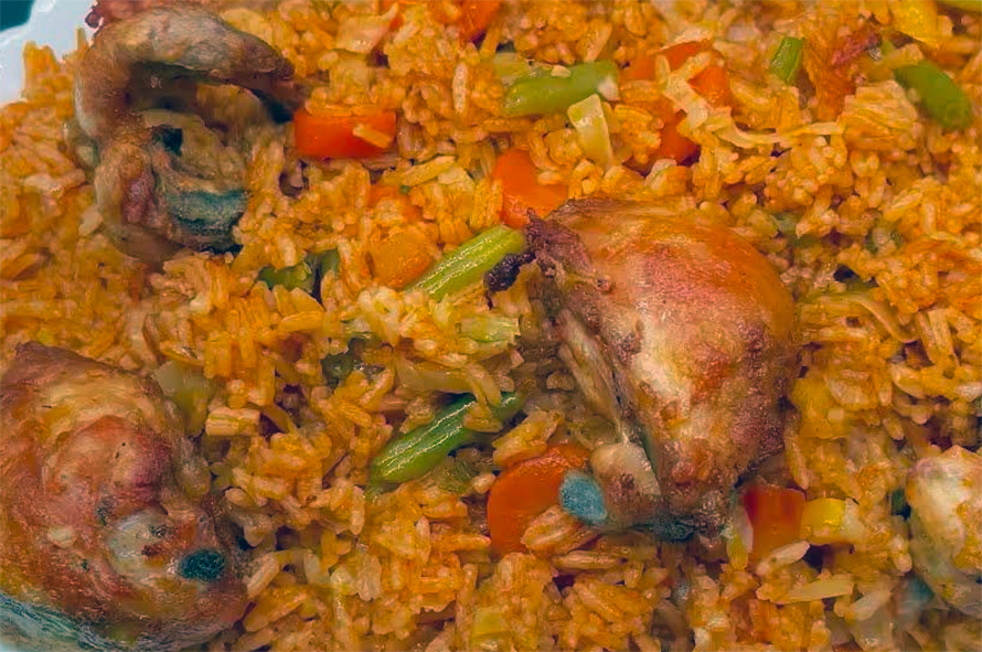 chicken mixed into rice and vegetables in a tomato base on a serving plate