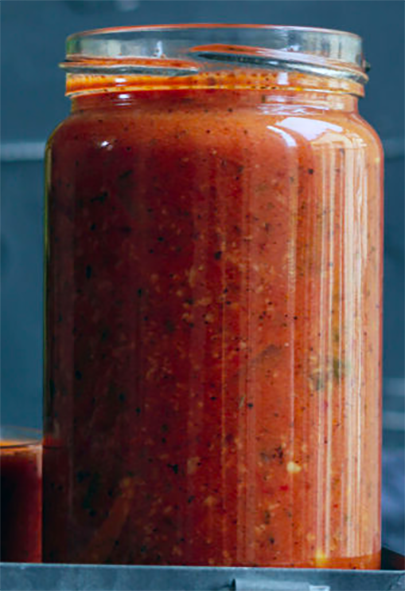 puree of roasted tomatoes and bell peppers with carrots and herbs in a jar