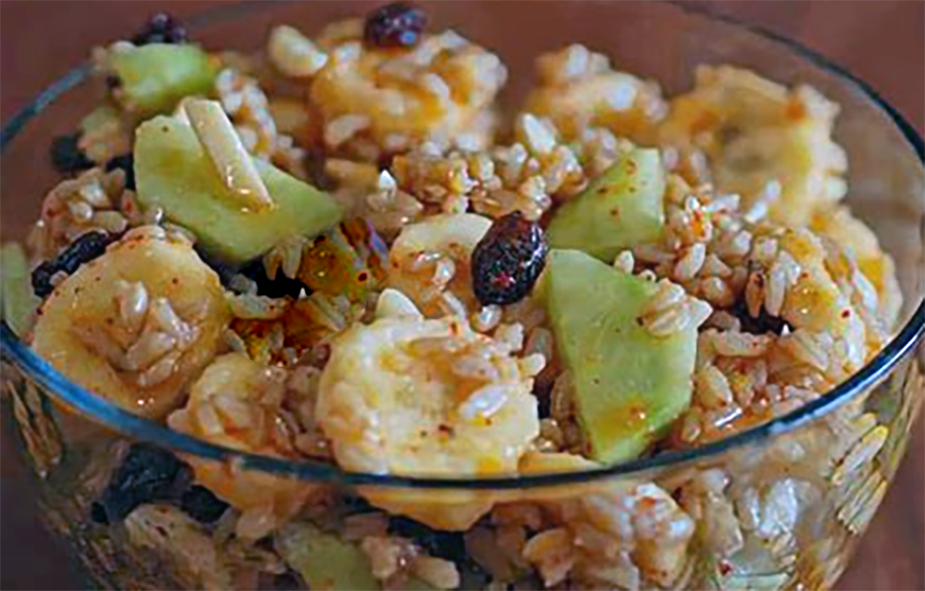 Chadian salad of rice mixed with cucumber, bananas, raisins and almonds served in a glass bowl