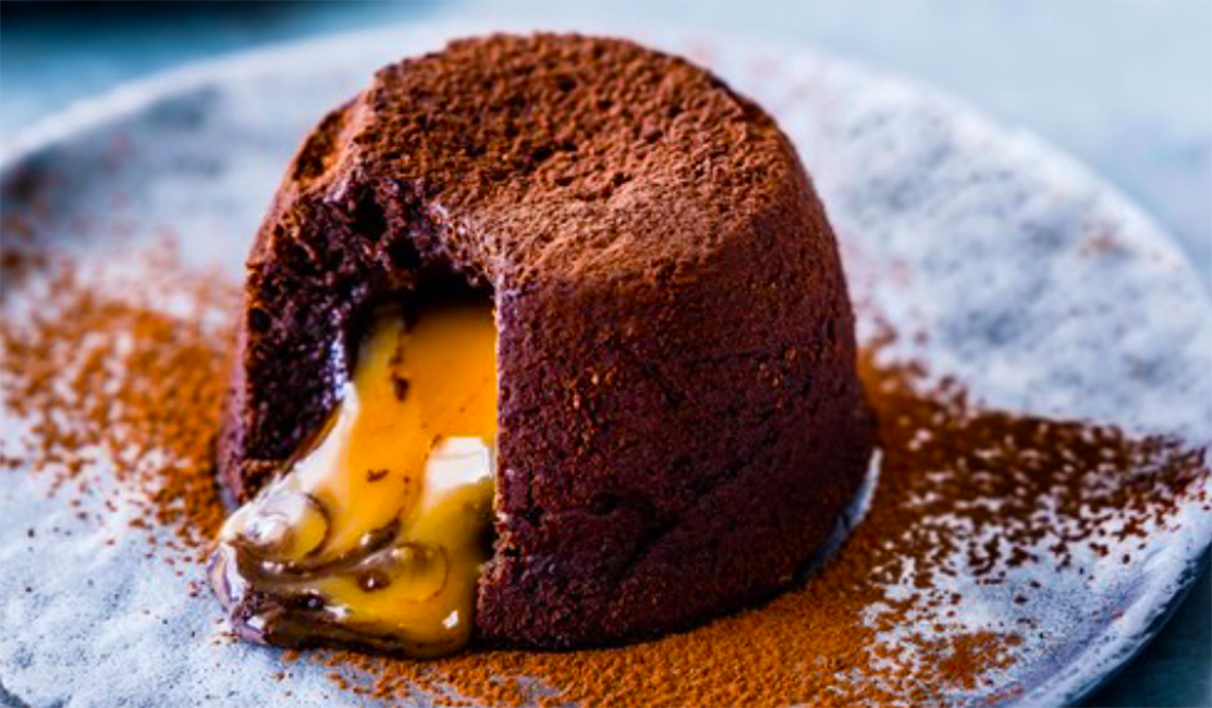 single Salted Caramel Chocolate Fondant dusted with chocolate on a plate, revealing the salted caramel filling
