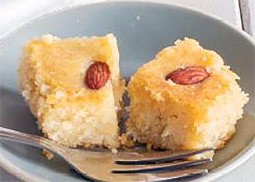 two squares of shimali, Cypriot semolina cakes topped with almonds served on a plate
