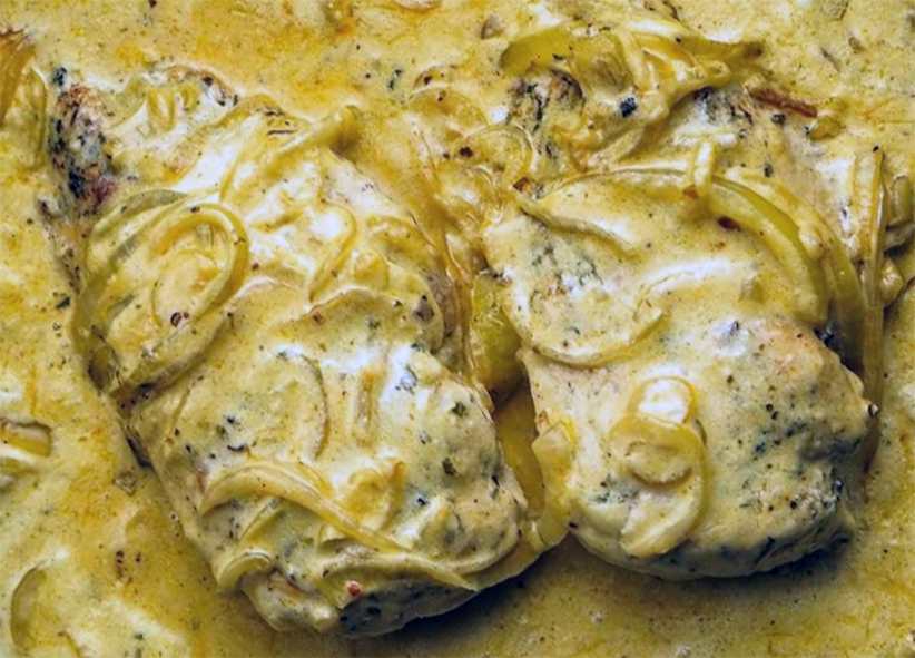 two chicken breasts in a sour cream sauce with onions and mushrooms