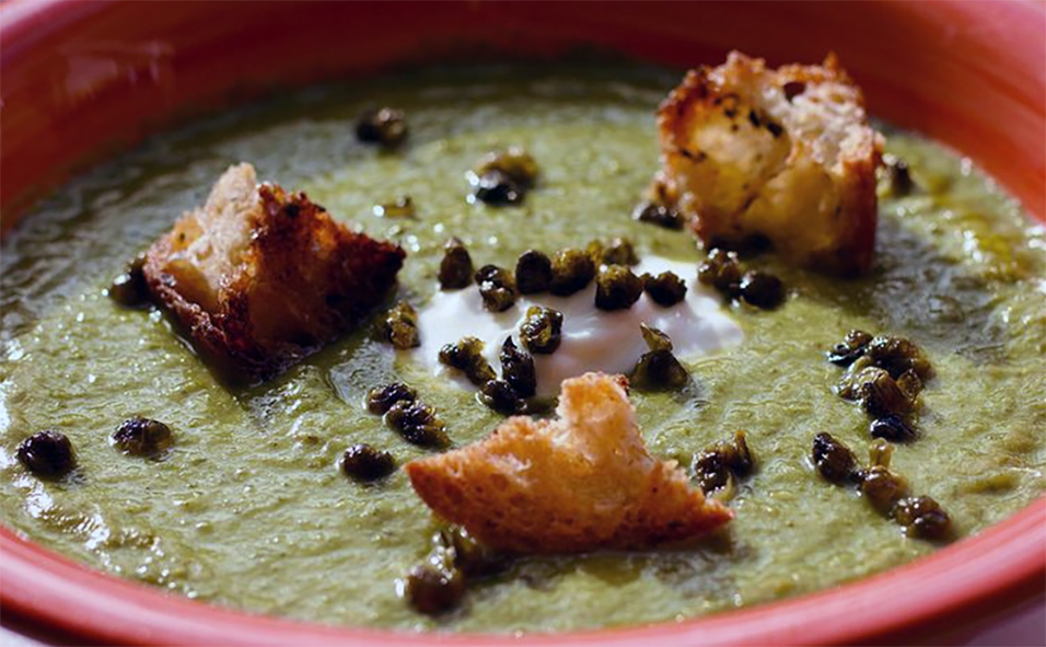 spinach and date soup garnished with currants and croutons