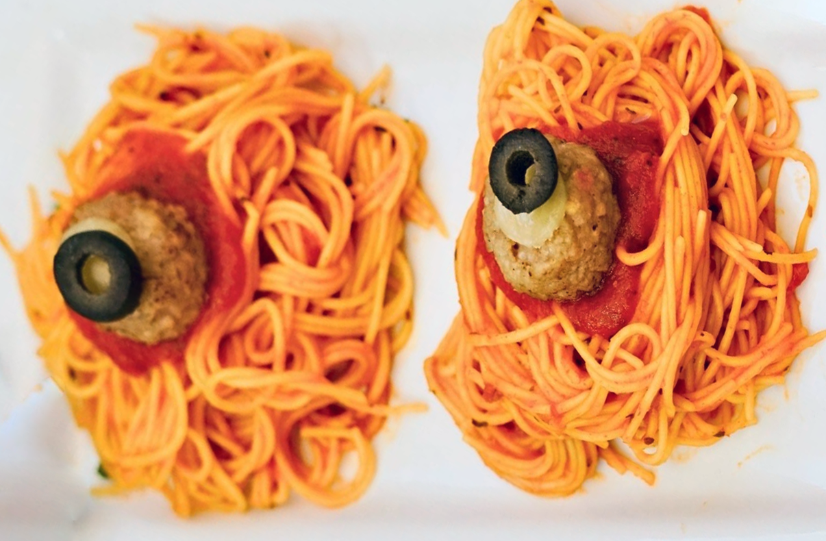 spaghetti topped with a meatball and a sliced olive as an eyeball