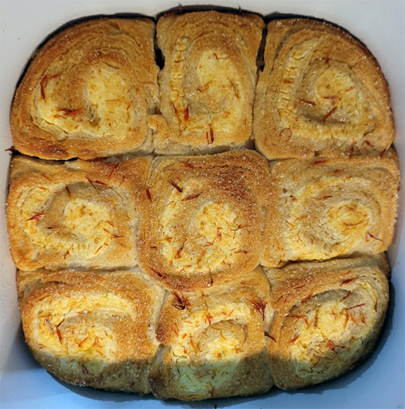 nine cream cheese buns with safflower garnished with safflower petals in a baking dish