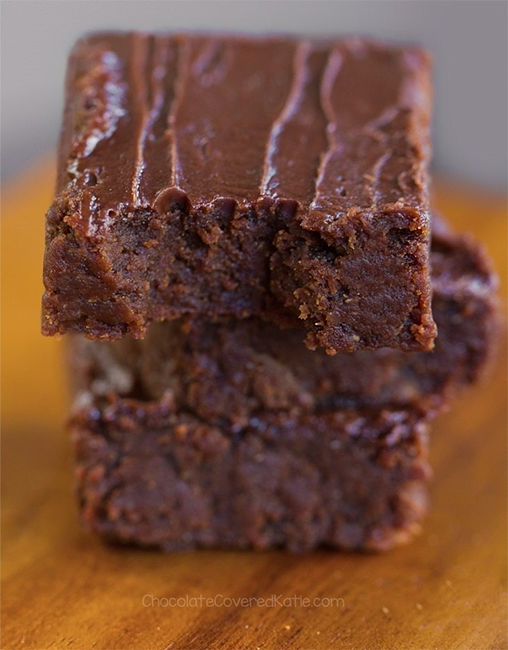 three squares of sweet potato brownies stacked on a wooden board