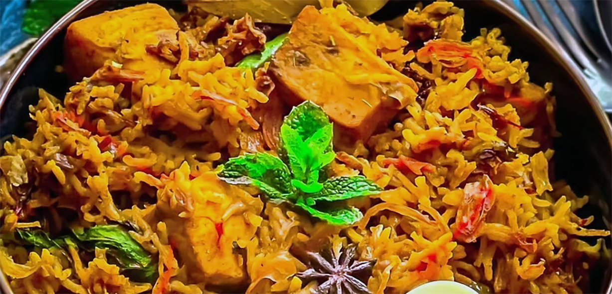 biryani of cubed swordfish in a metal dish