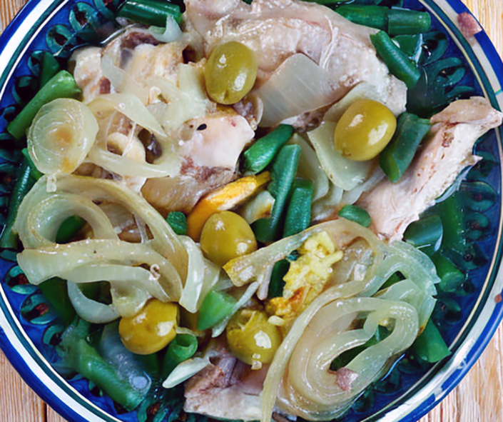 tagine of chicken with olives, preserved lemons and onion on a plate