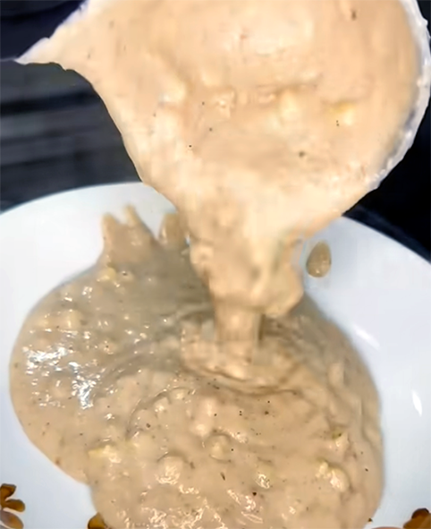 thiove, hominy, peanut and ground bean porridge ladled onto a plate