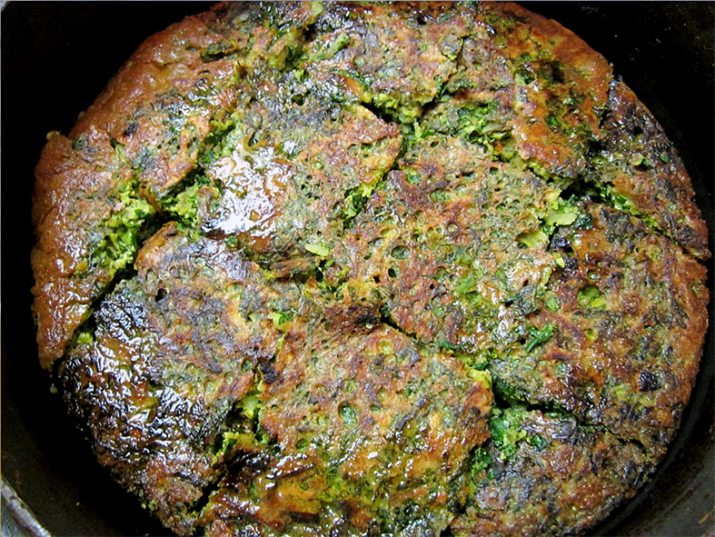 kookoo sabzi turned out onto a plate and cut into wedges