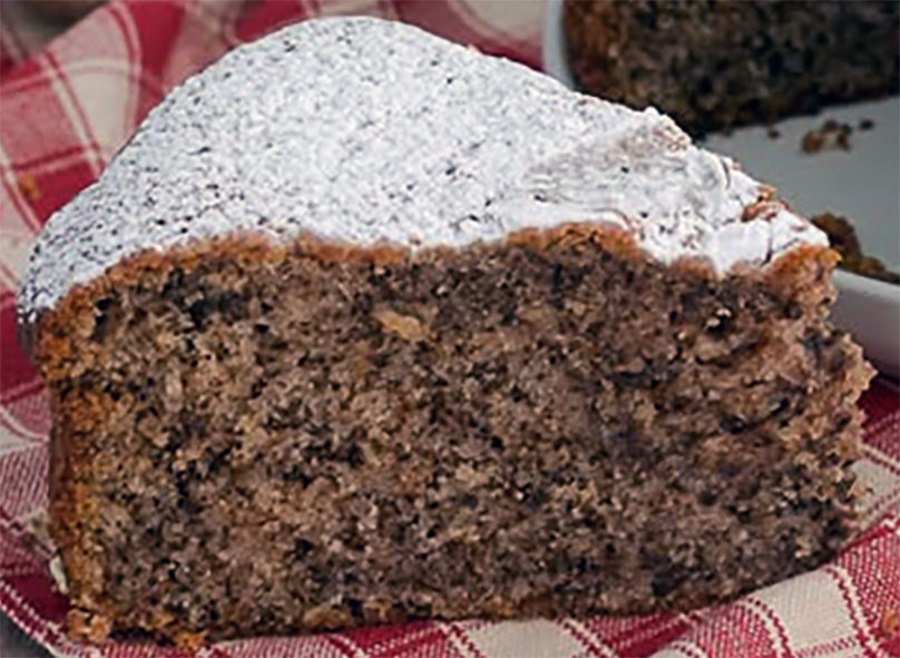 slice of italian walnut cake dusted with icing sugar on a check tablecloth