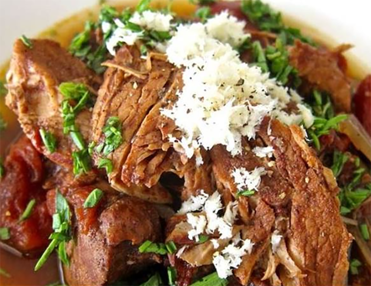 piquant pork stew in a bowl topped with finely-grated horseradish