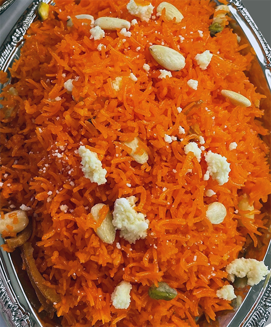 Pakistani zarda rice garnished with khoya in a serving dish