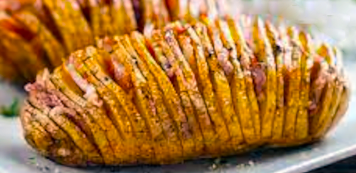 hasselback potato cooked until crisp in an air fryer on a plate with another in the background
