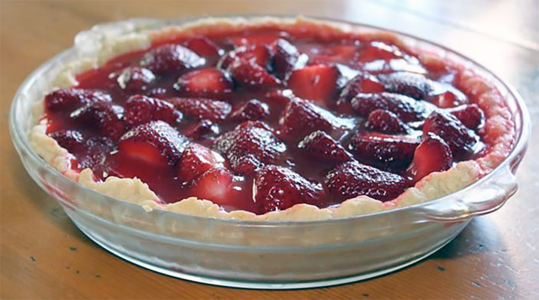 Amish country strawberry pie in glass dish on a wooden table