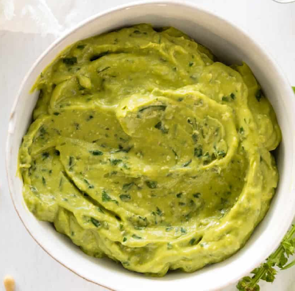 avocado leaf and basil leaf pesto presented in a white bowl