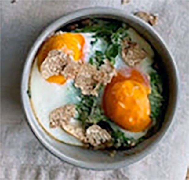 eggs baked in an earthenware dish with a garnish of summer truffle shavings