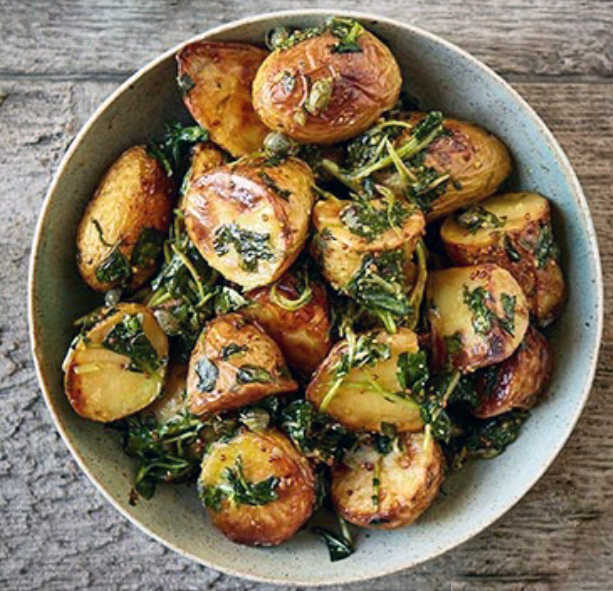 baked new potatoes with wilted wild garlic served in a bowl