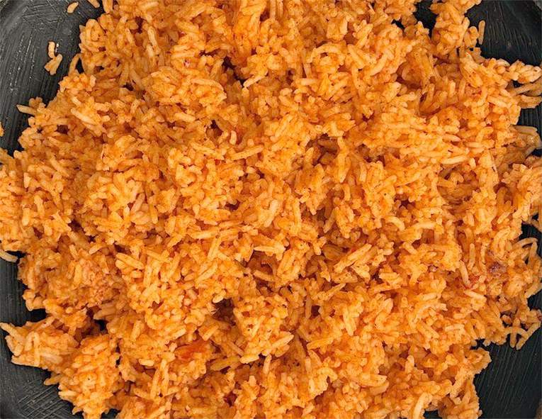 basic jollof rice piled on a black plate