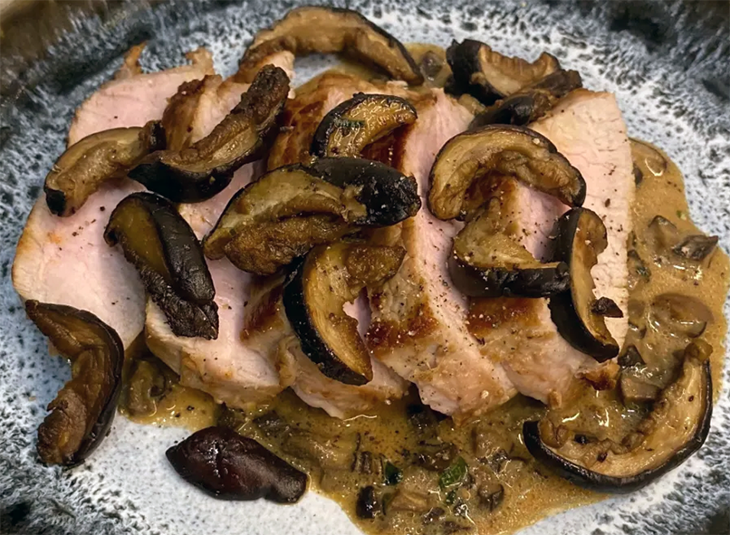 veal slices topped with fried bay boletes on a bolete and sage sauce base