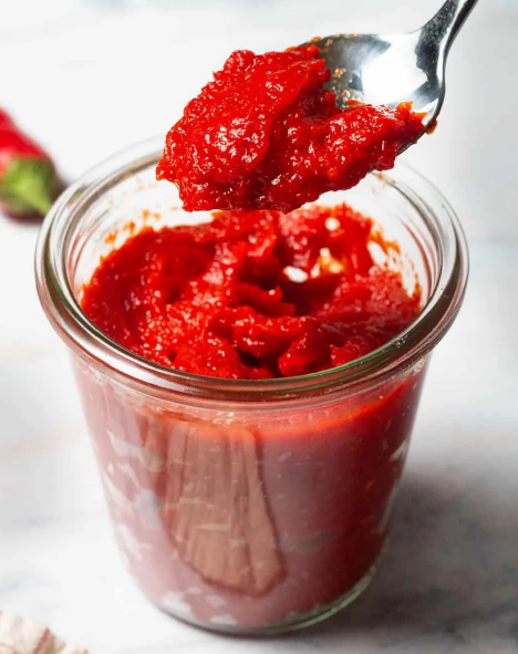 Biber Salçası, Turkish red pepper paste in a jar lifted with a spoon