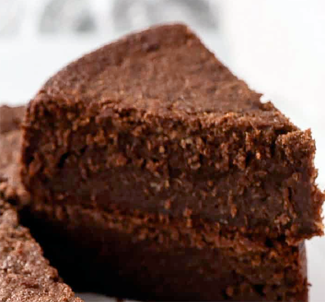 slice of black cake cut from the cake and stacked on the main body of the cake